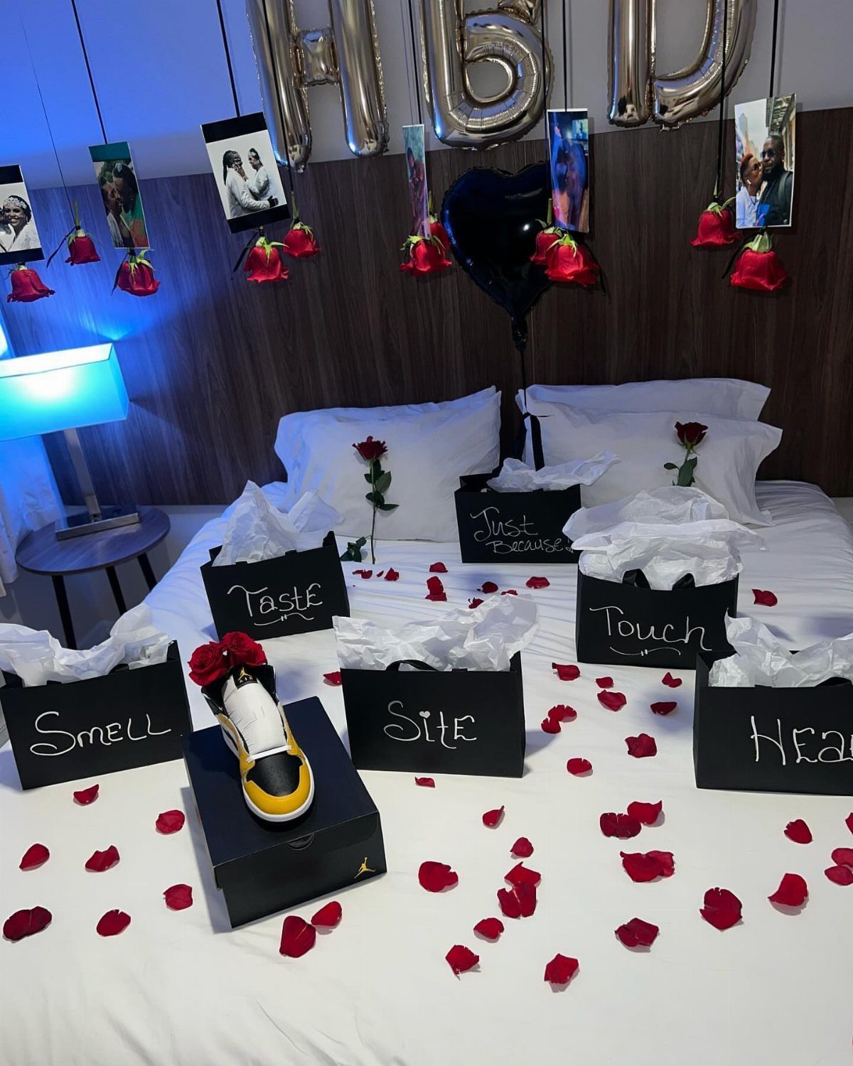 Five labeled gift boxes for the five senses on a bed with rose petals.