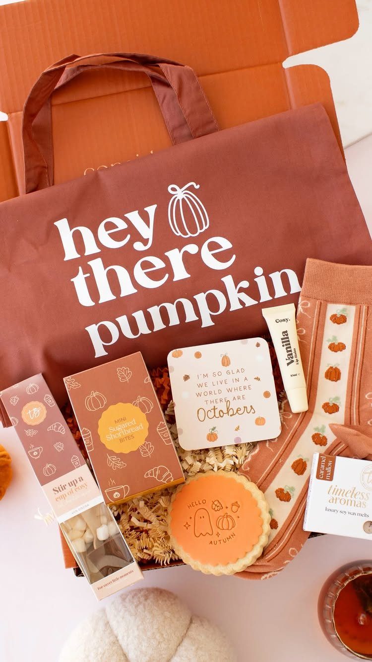 Autumn gift box with a pumpkin tote bag, decorated cookie, and seasonal treats.