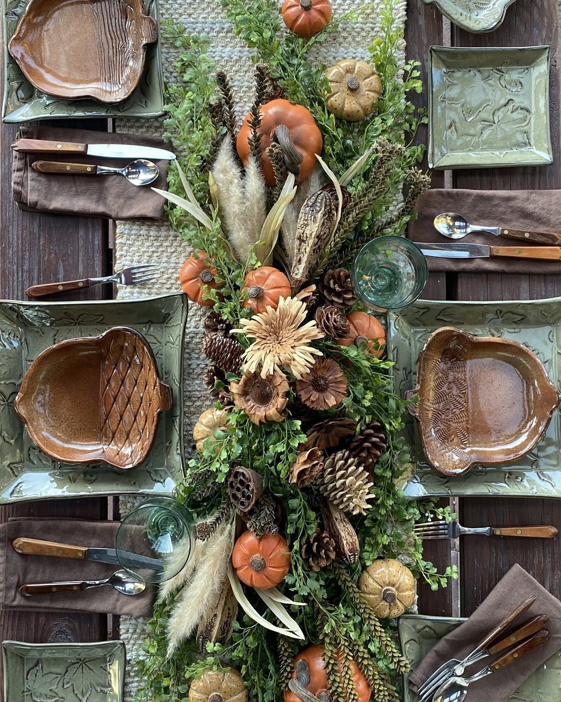 Autumn table setting with pumpkin-shaped bowls, green plates, and a harvest centerpiece.