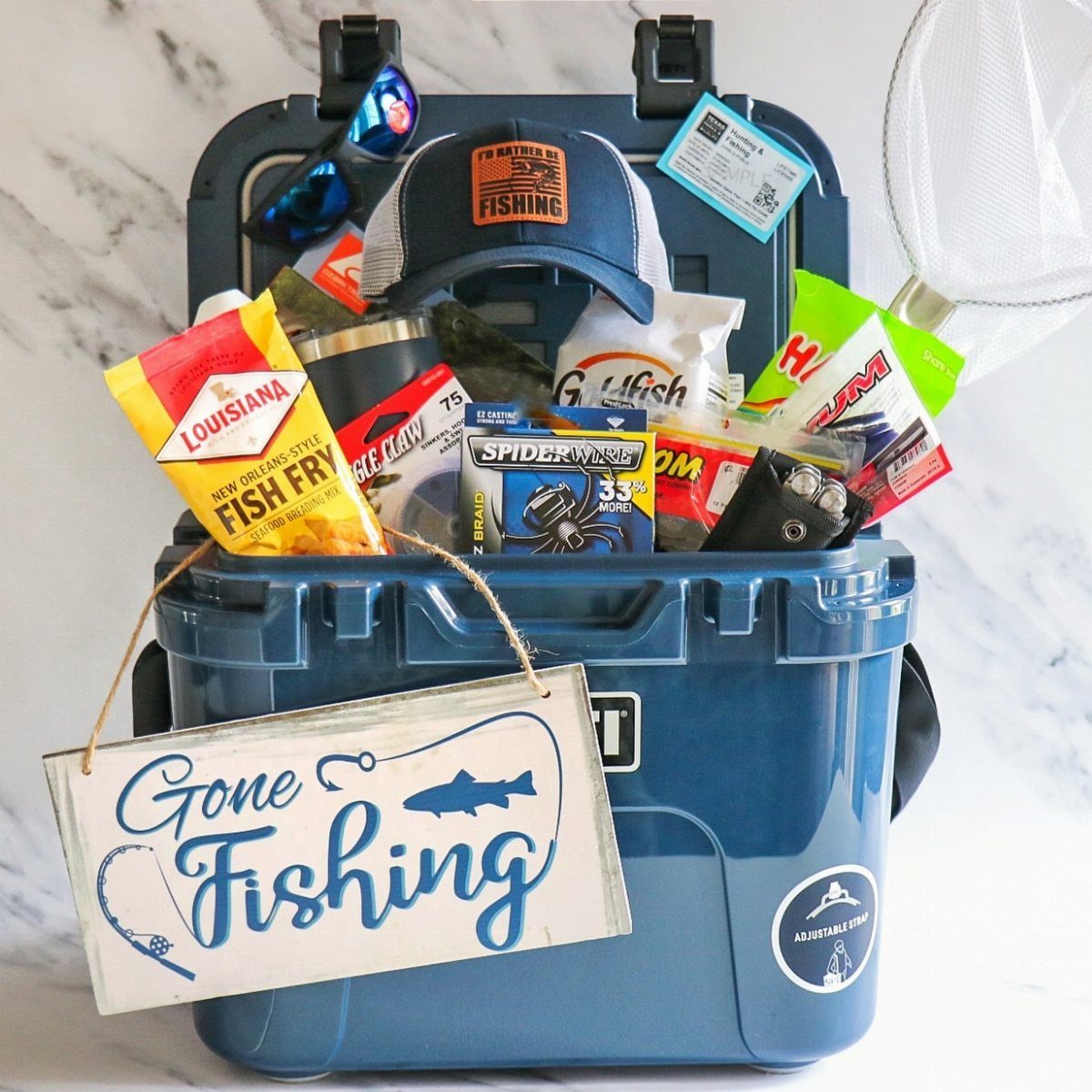 Blue cooler filled with fishing gear and a Gone Fishing wooden sign.