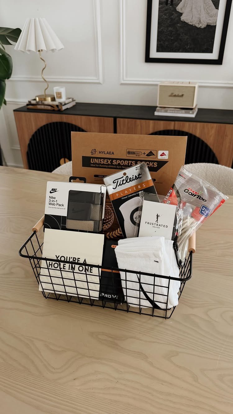 Golf-themed gift basket with golf balls, socks, and a celebratory card on a table.