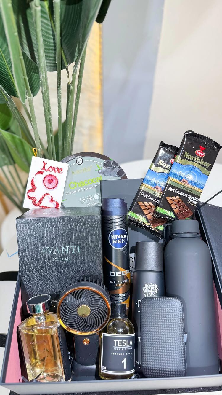 Gift box with perfume, electric shaver, deodorant, water bottle, and chocolate bars.