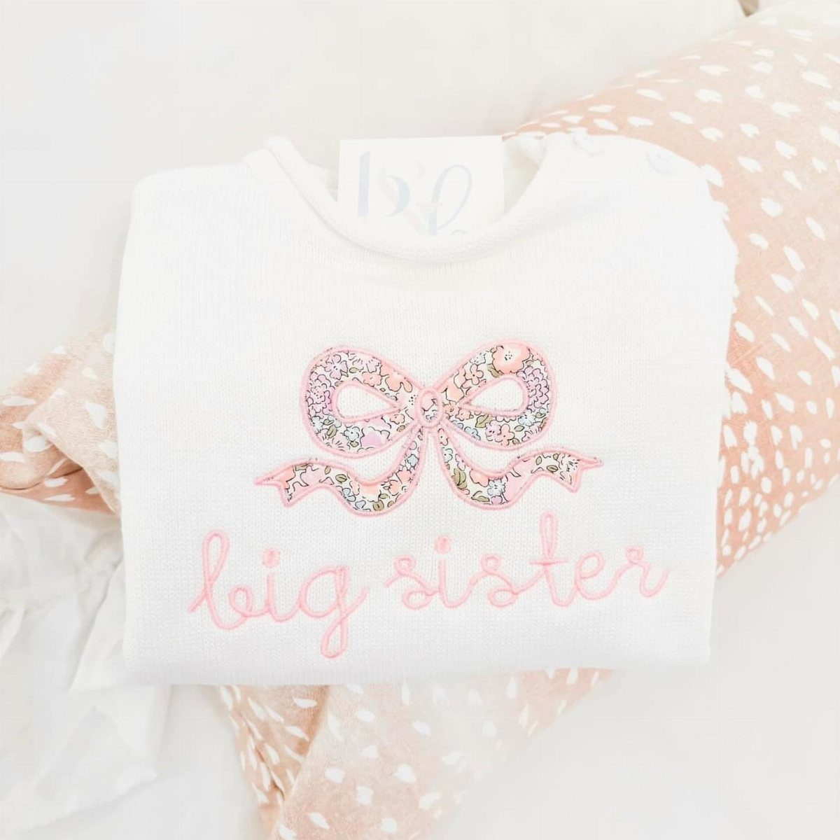 White knit sweater with pink floral bow and big sister embroidery on fabric