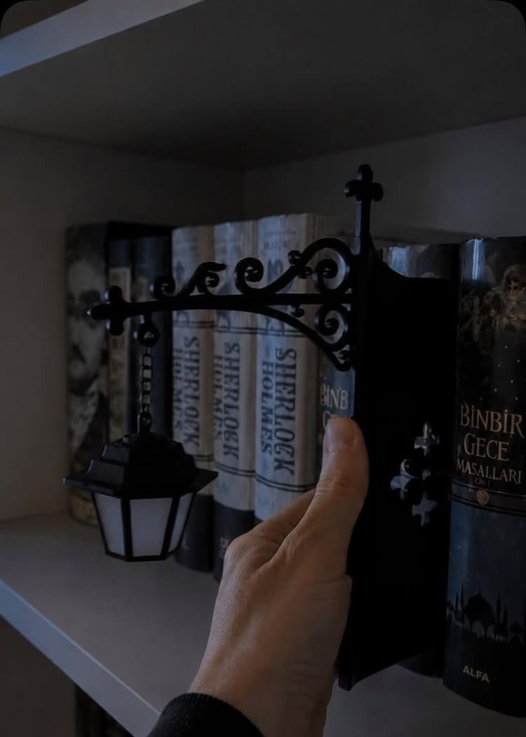 Black street lamp bookend holding up a row of books on a shelf