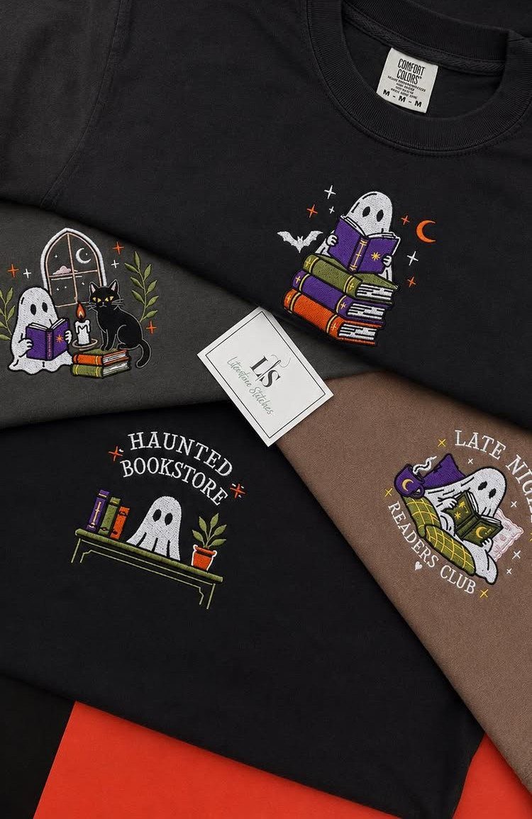 Embroidered t-shirts featuring ghosts reading books and literary-themed text on dark fabrics.
