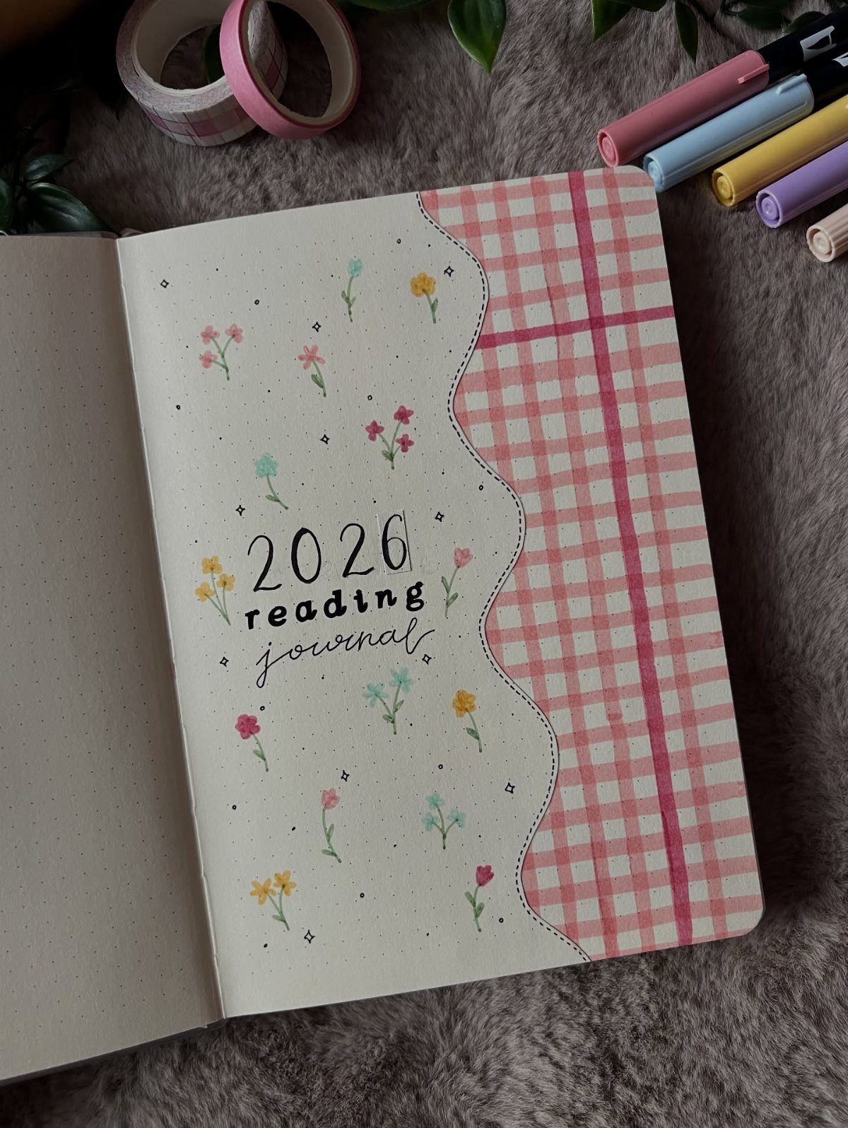 Reading journal with floral decorations and pink gingham pattern on a fuzzy background.