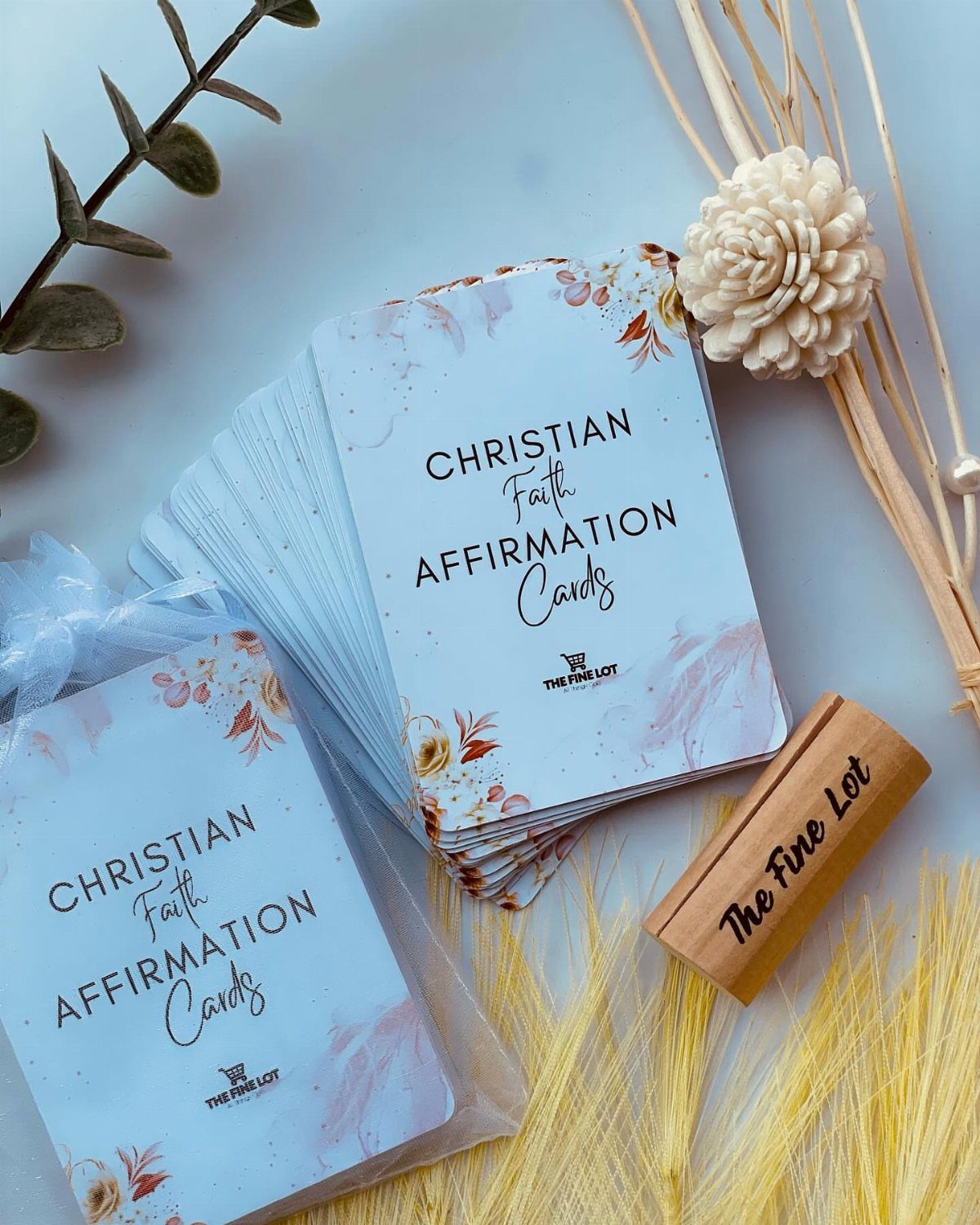 Christian faith affirmation cards in stacks with a wooden stamp and dried flowers.