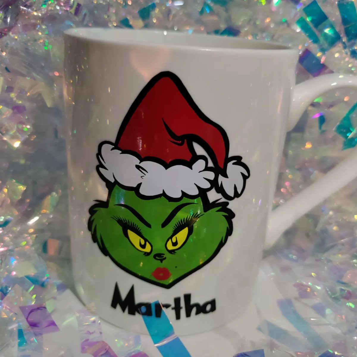 White coffee mug with a Grinch-themed Martha May Whovier illustration and name.