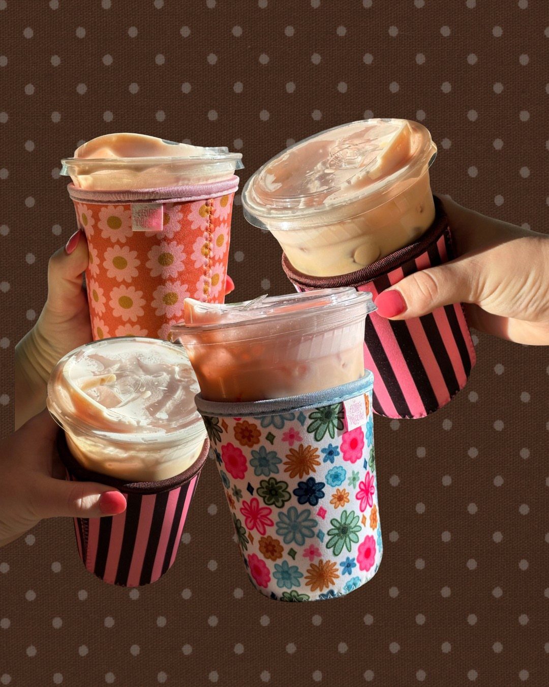 Four iced coffee cups wrapped in colorful floral and striped fabric reusable sleeves.