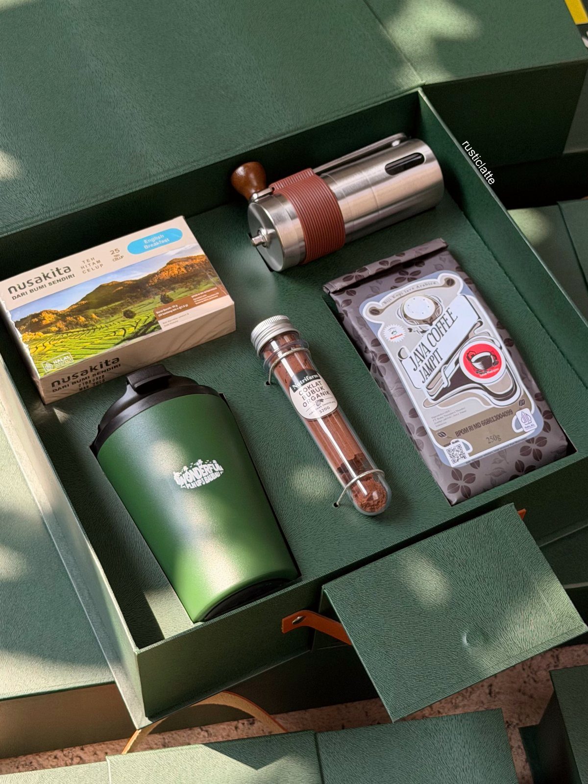 Coffee gift set in a green box with a manual grinder and travel mug