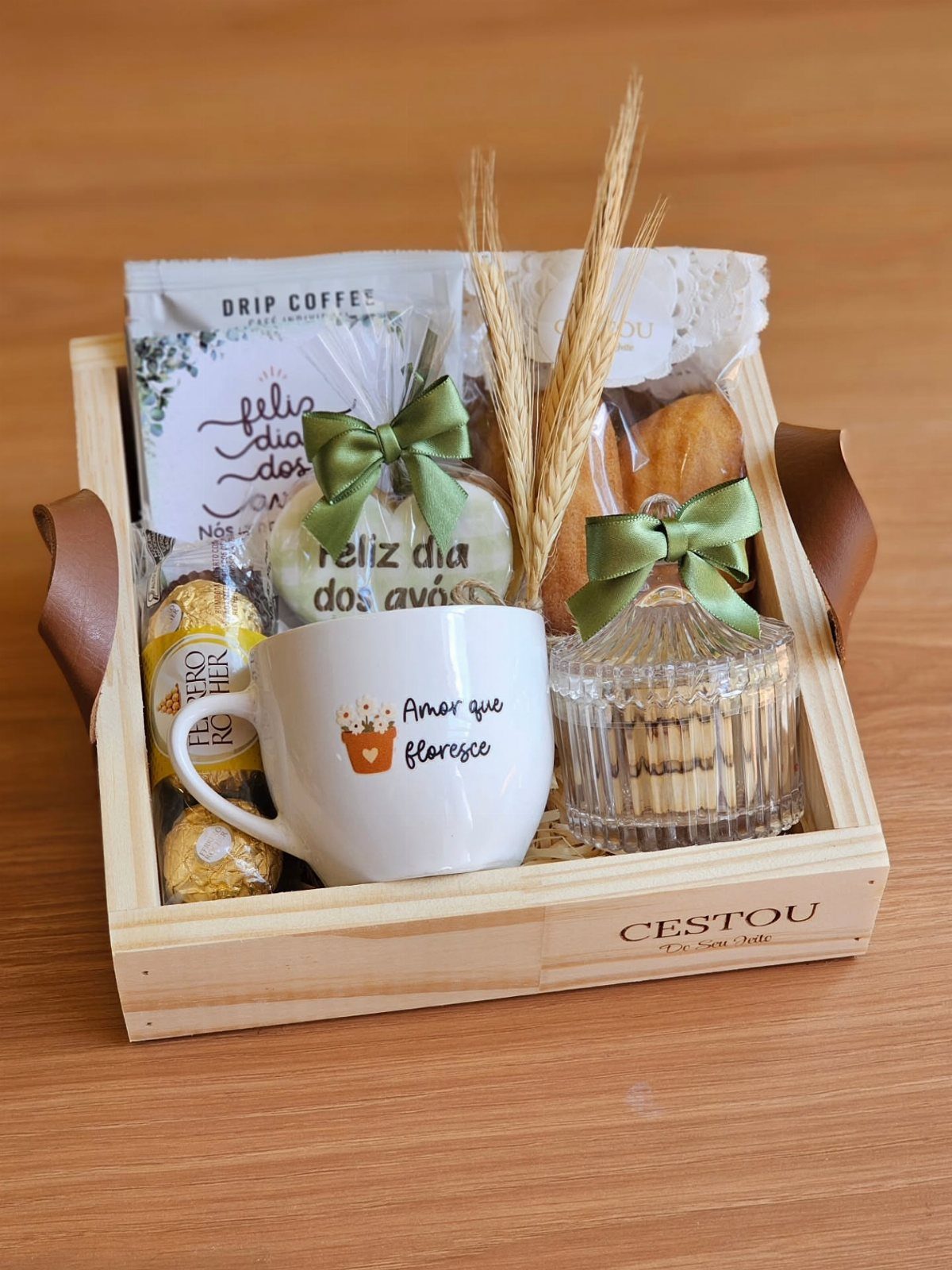 Coffee gift basket in a wooden crate with a mug, sweets, and coffee.