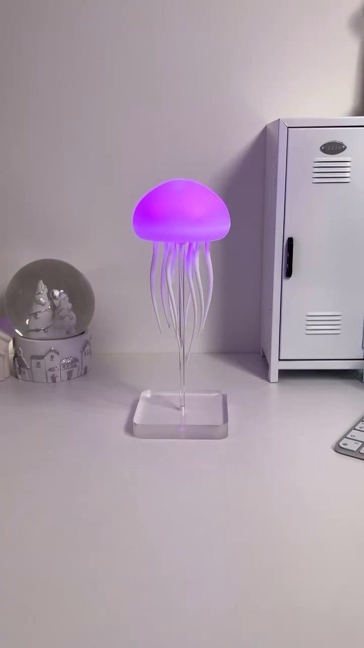 Purple glowing jellyfish lamp on a white desk next to a small locker.