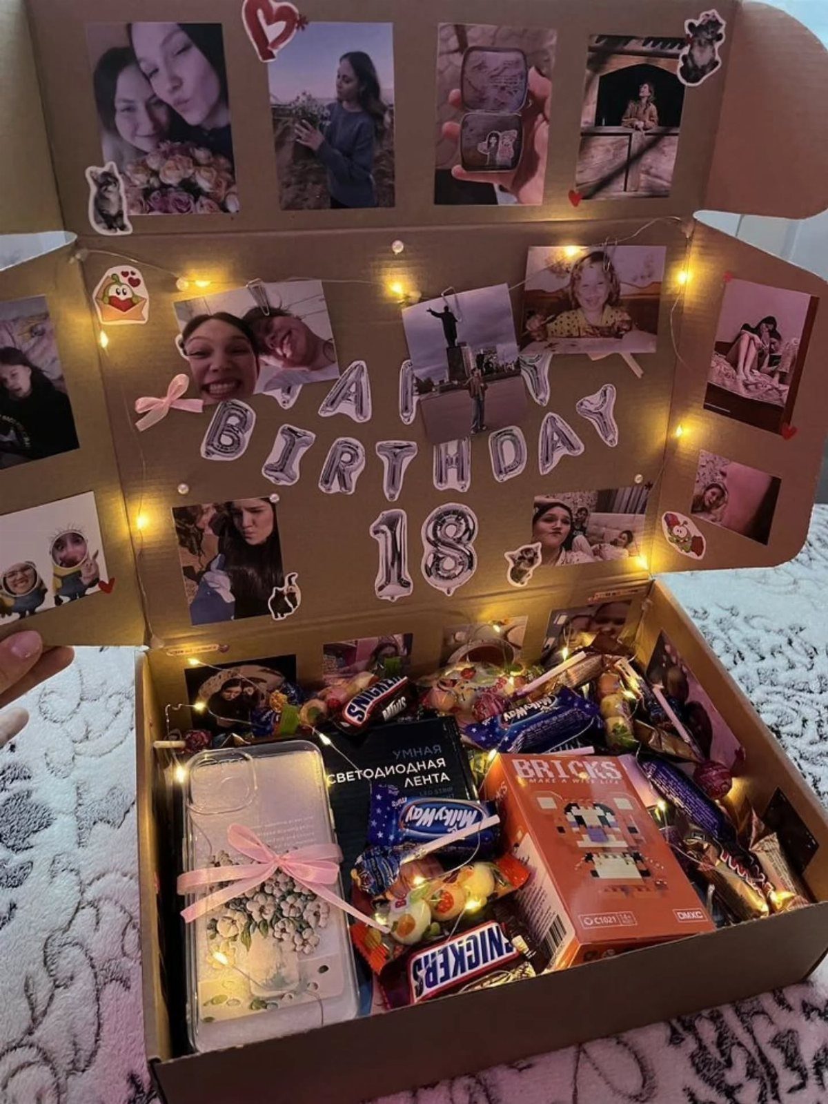 Birthday gift box filled with sweets and photos decorated with fairy lights
