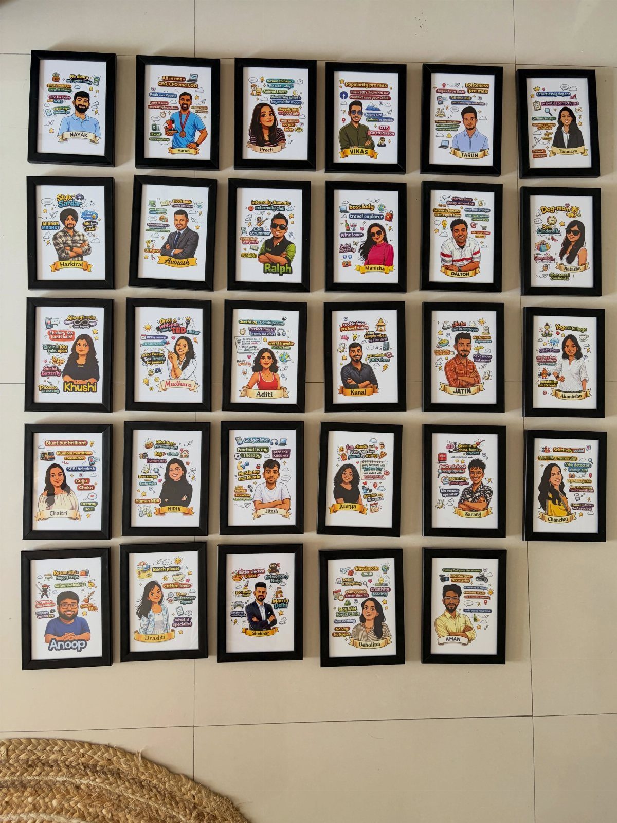 Grid of framed cartoon portraits of people hanging on a white wall.