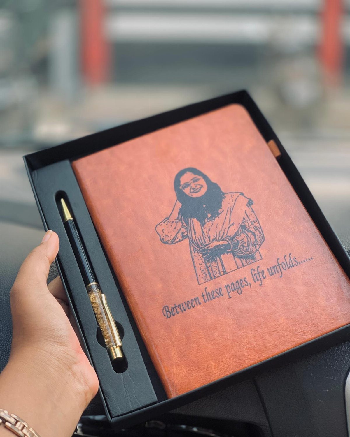 Orange leather notebook and gold pen in a black gift box