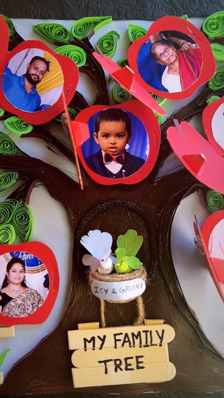 Handmade 3D family tree craft with photos of family members in red frames.
