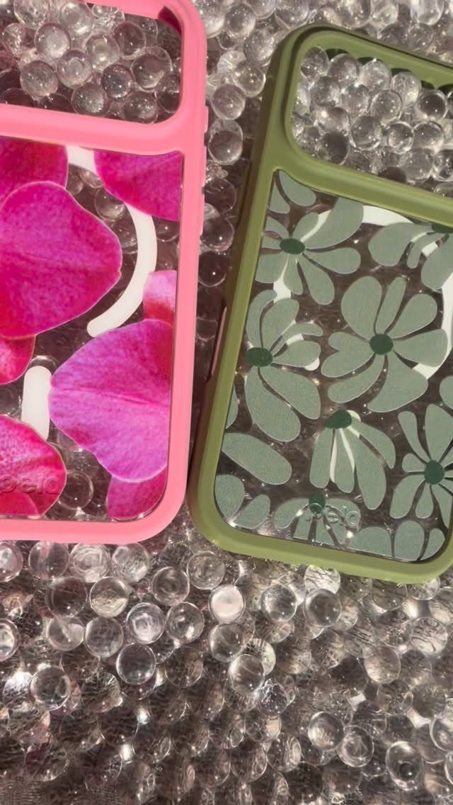 Two floral pressed flower phone cases resting on clear translucent water beads.