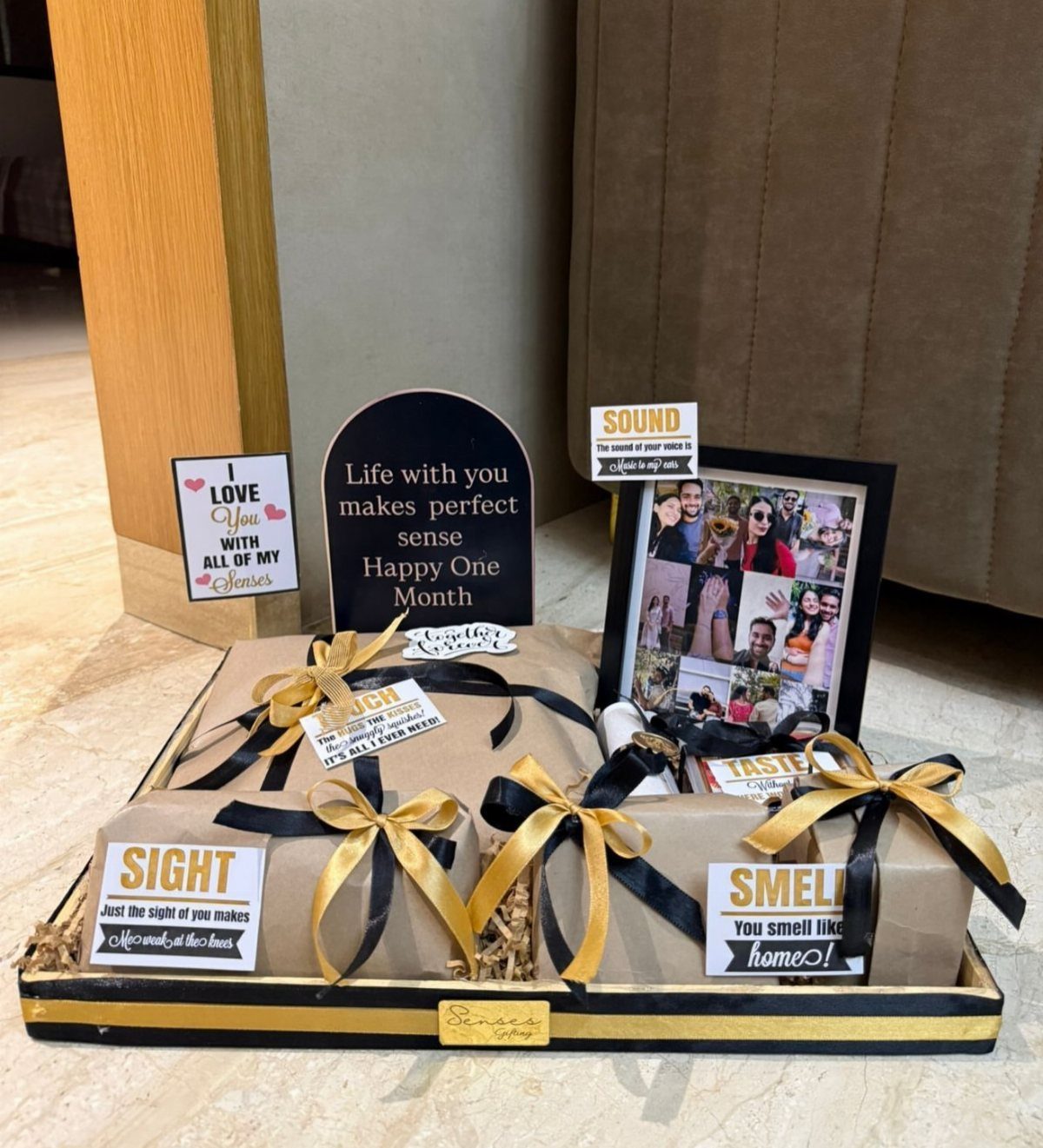 Gift hamper with wrapped boxes, photo frame, and five senses themed cards.