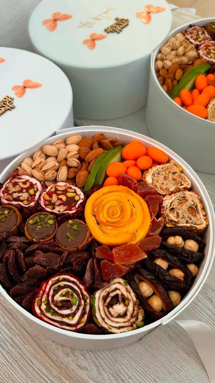 Gourmet snack basket filled with dried fruits, nuts, and sweets in a white box