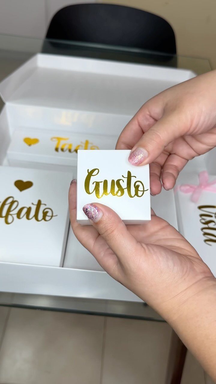 Hands holding a white gift box labeled Gusto among other sensory-themed boxes.
