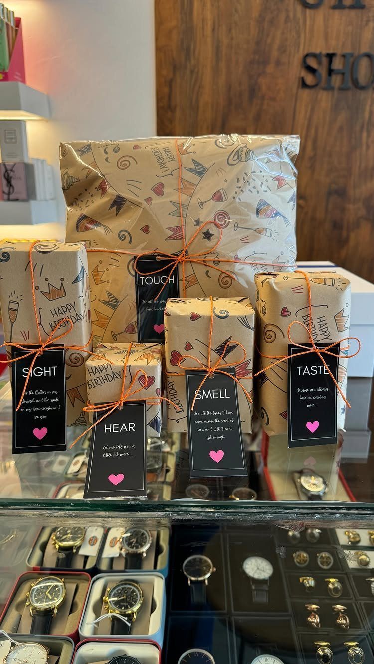 Wrapped gifts with tags for the five senses displayed on a glass counter
