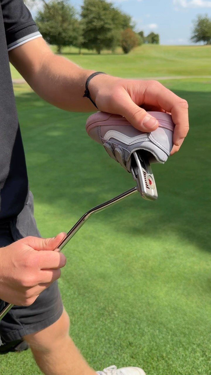 Modified golf putter with a pink and grey sneaker attached to the head