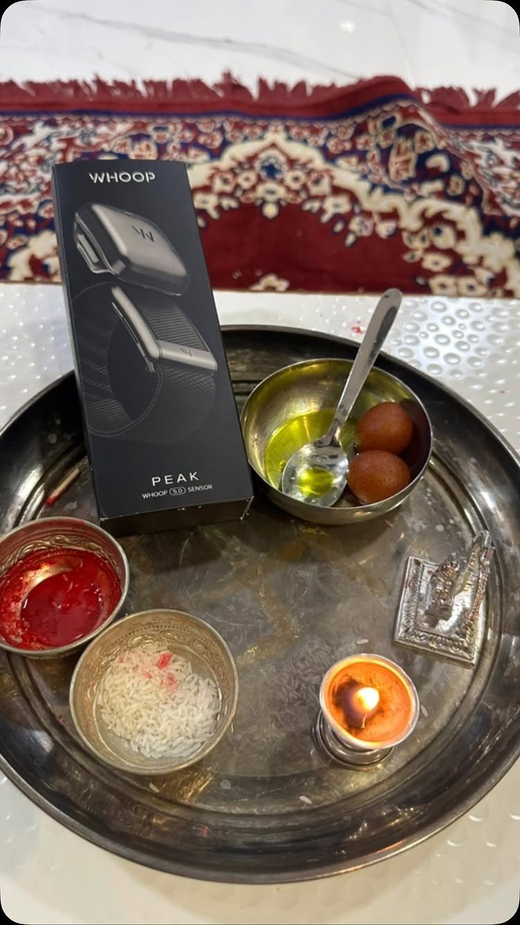 Whoop fitness tracker box on a ceremonial tray with sweets and a candle