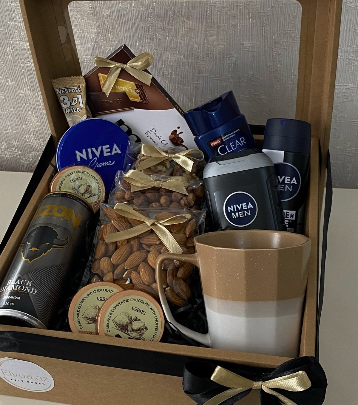 Gift hamper with Nivea Men products, almonds, and a mug in a box.