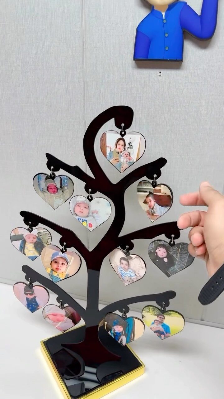 Black acrylic tree photo holder with heart-shaped family portraits hanging from branches