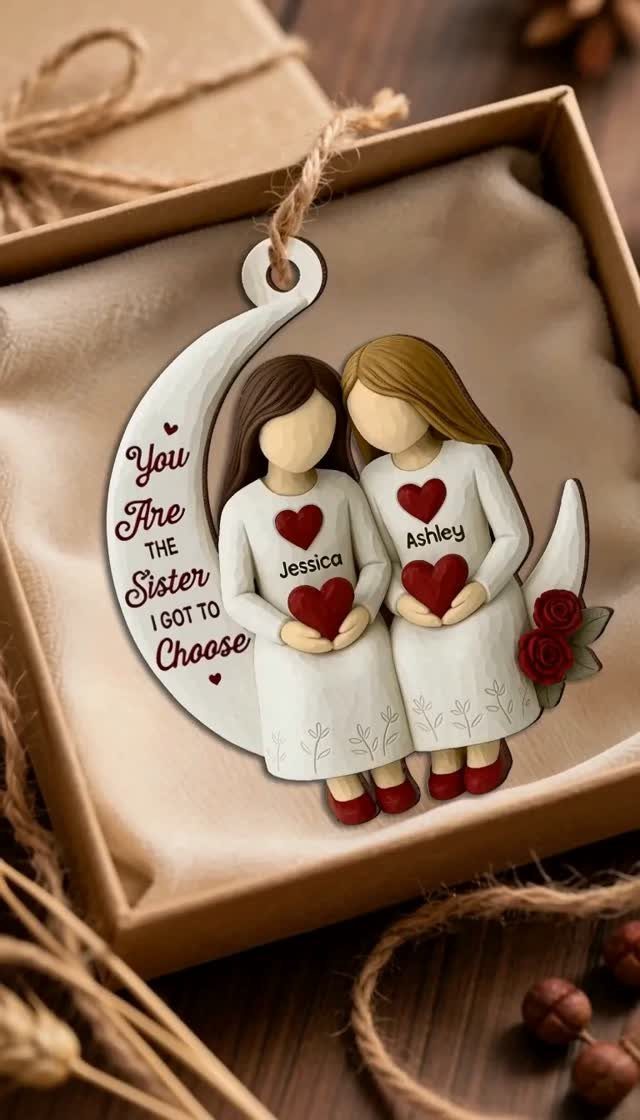 Wooden ornament of two sisters holding hearts in a gift box