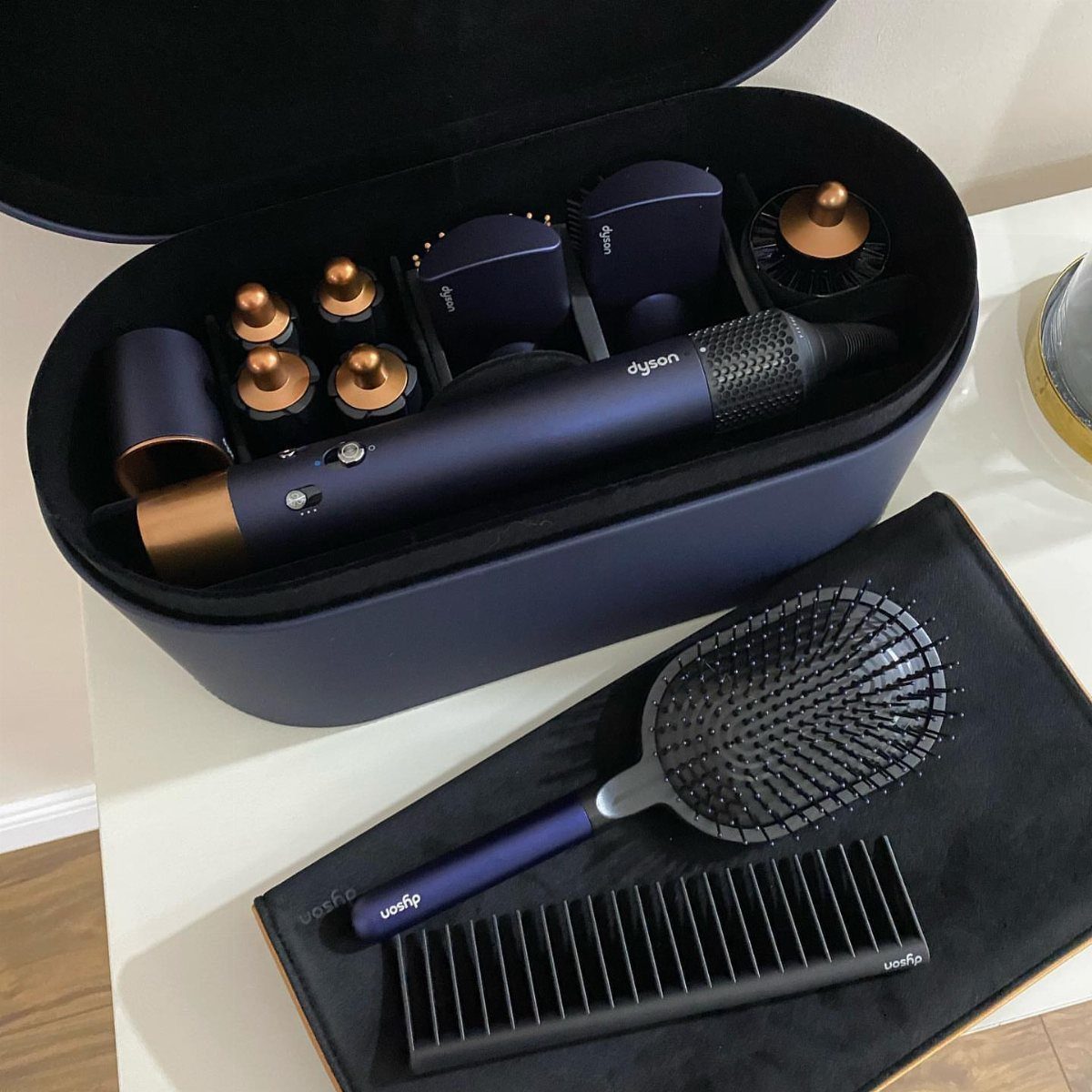 Navy blue Dyson Airwrap multi-styler with attachments in a matching storage case.