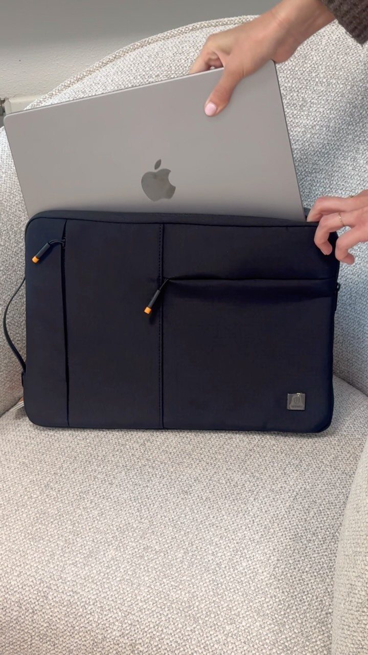 Silver laptop being placed into a black protective laptop sleeve on a chair