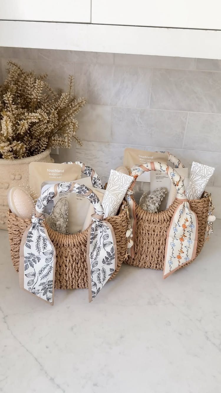 Two woven straw gift baskets filled with skincare products and decorative fabric bows.