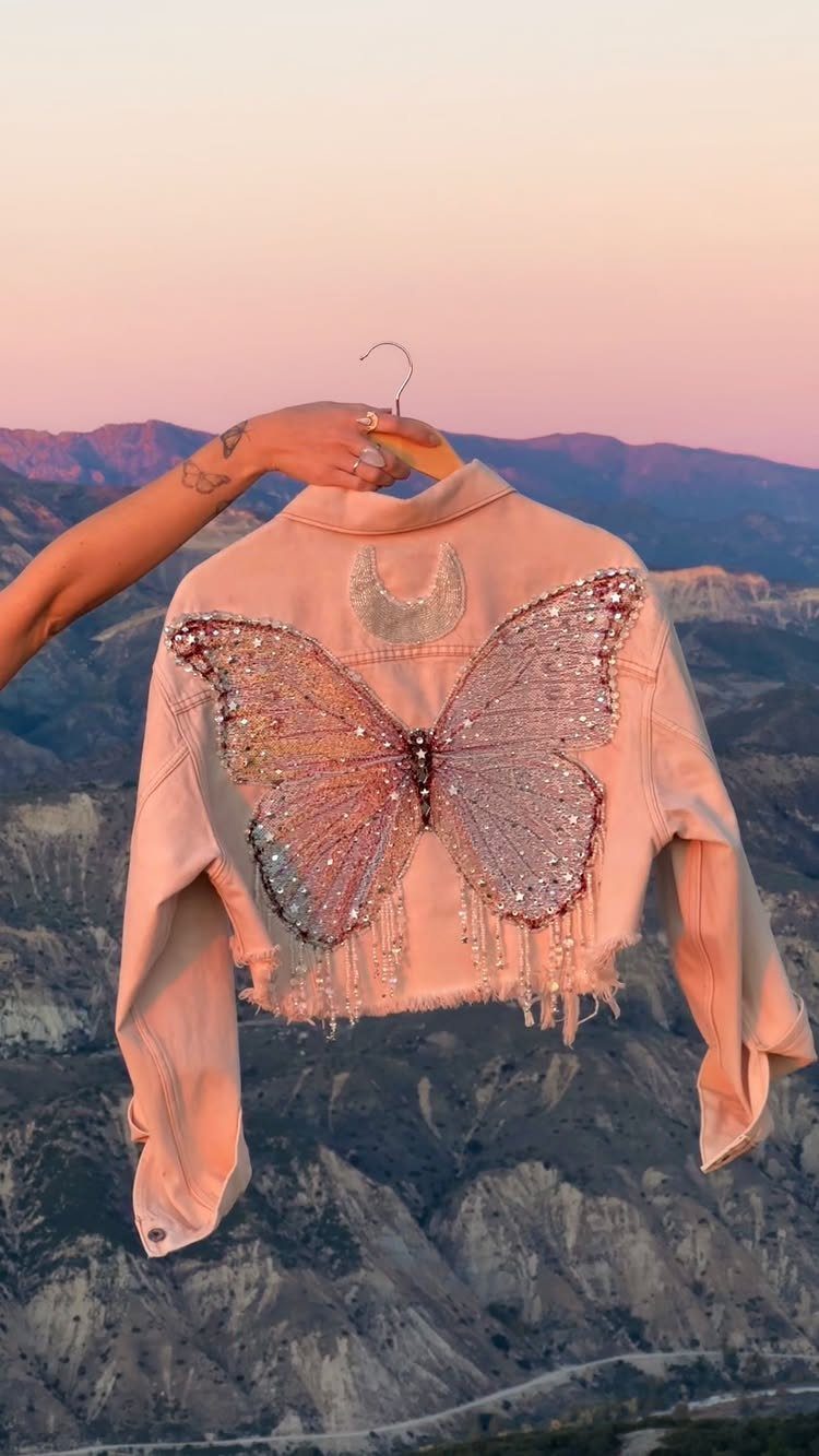 Pink denim jacket with a large shimmering sequined butterfly on the back.