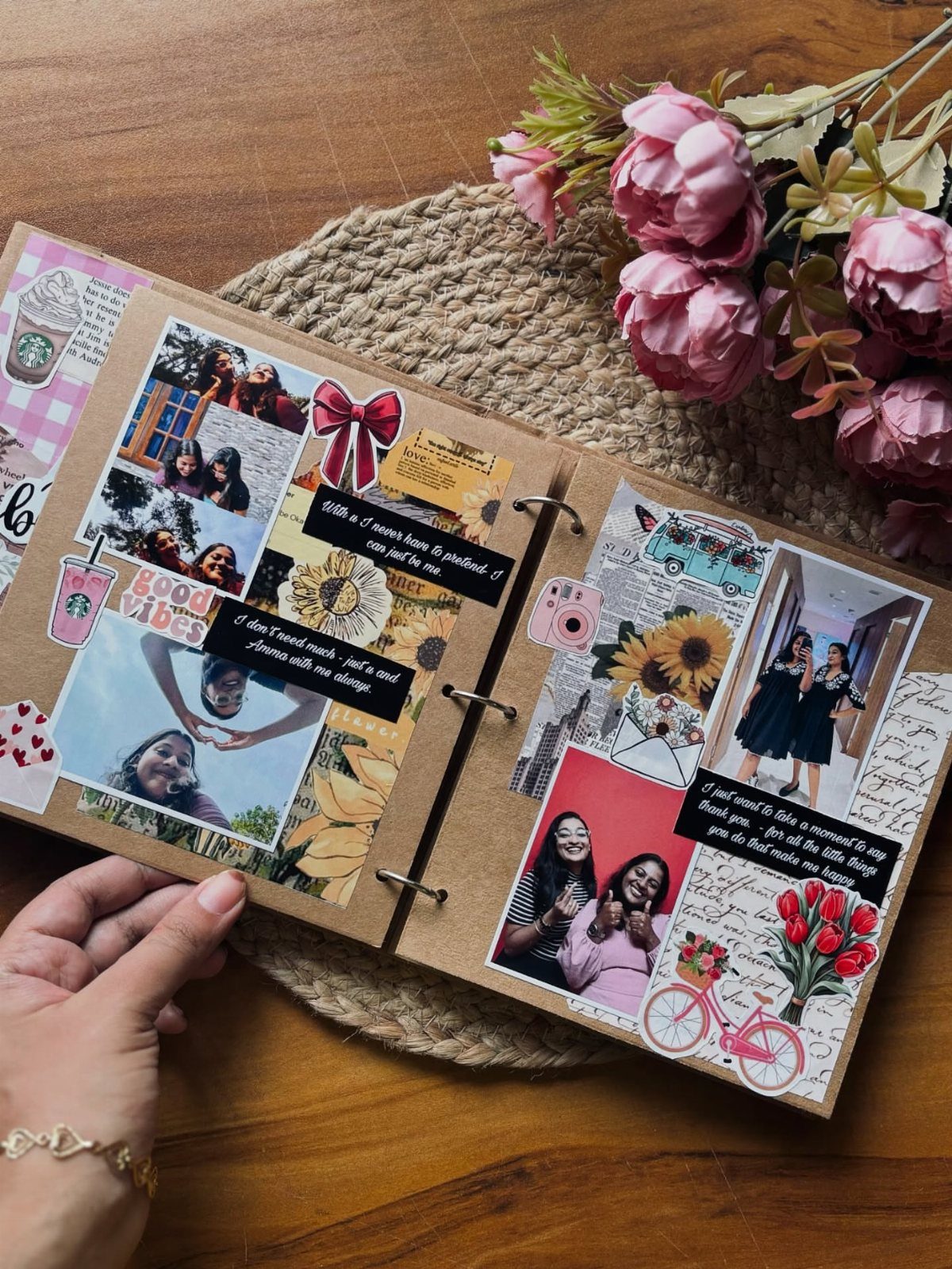 Handmade scrapbook with photos and stickers held open over a wooden table.