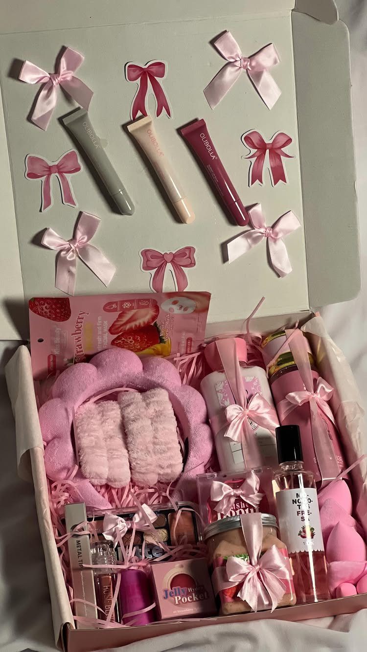 Pink and white beauty gift box with skincare products, slippers, and satin bows.