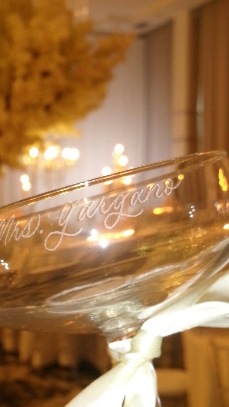 Engraved martini glass with cursive text Mrs. Largano in a warm indoor setting