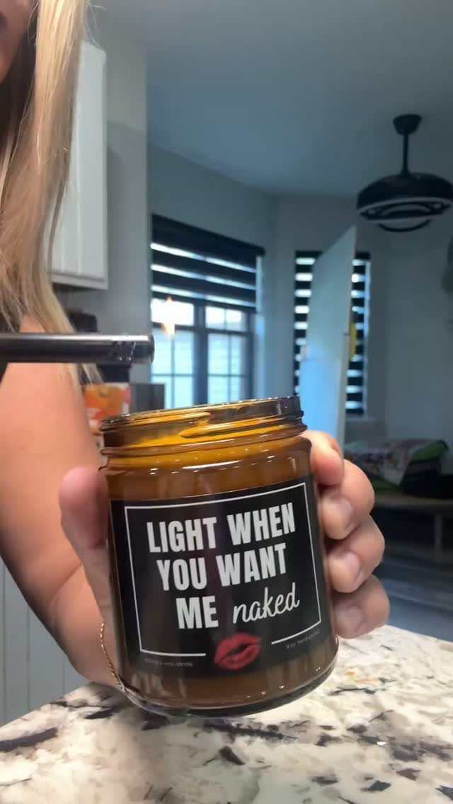 Brown scented candle in a glass jar with a humorous message on the label.
