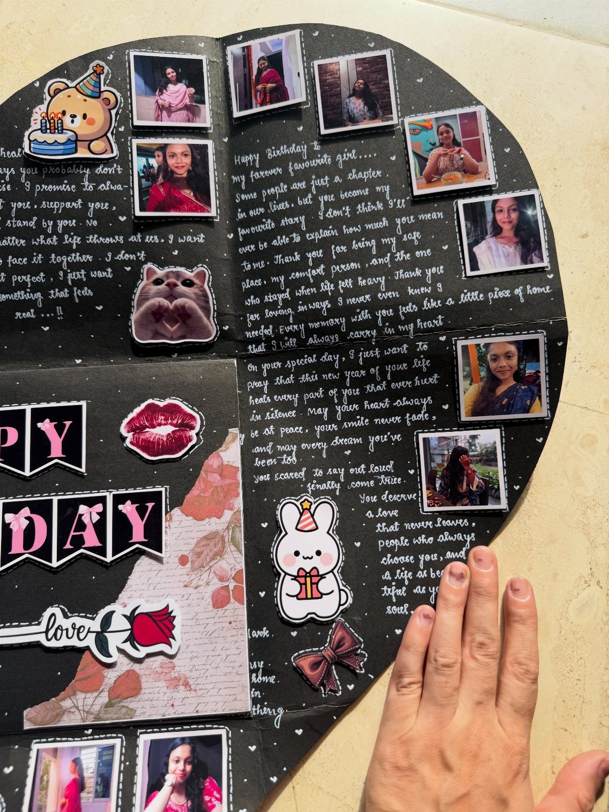 Open black scrapbook with photos, handwritten notes, and stickers for a birthday gift