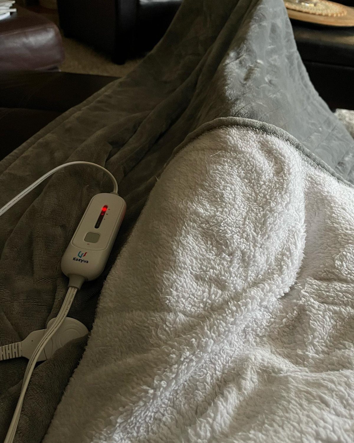 Grey and white plush electric blanket with a white handheld remote control.