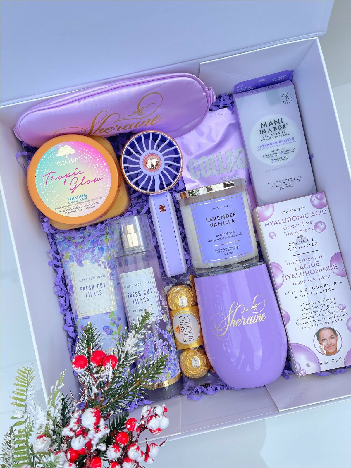 Self-care gift box with purple skincare products, a candle, and a purple pouch.