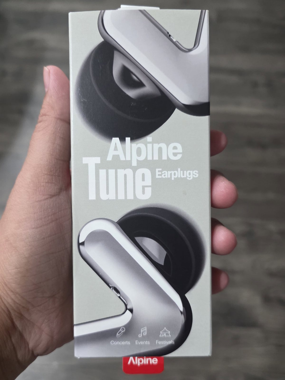 Alpine Tune Earplugs product box held in a person's hand.