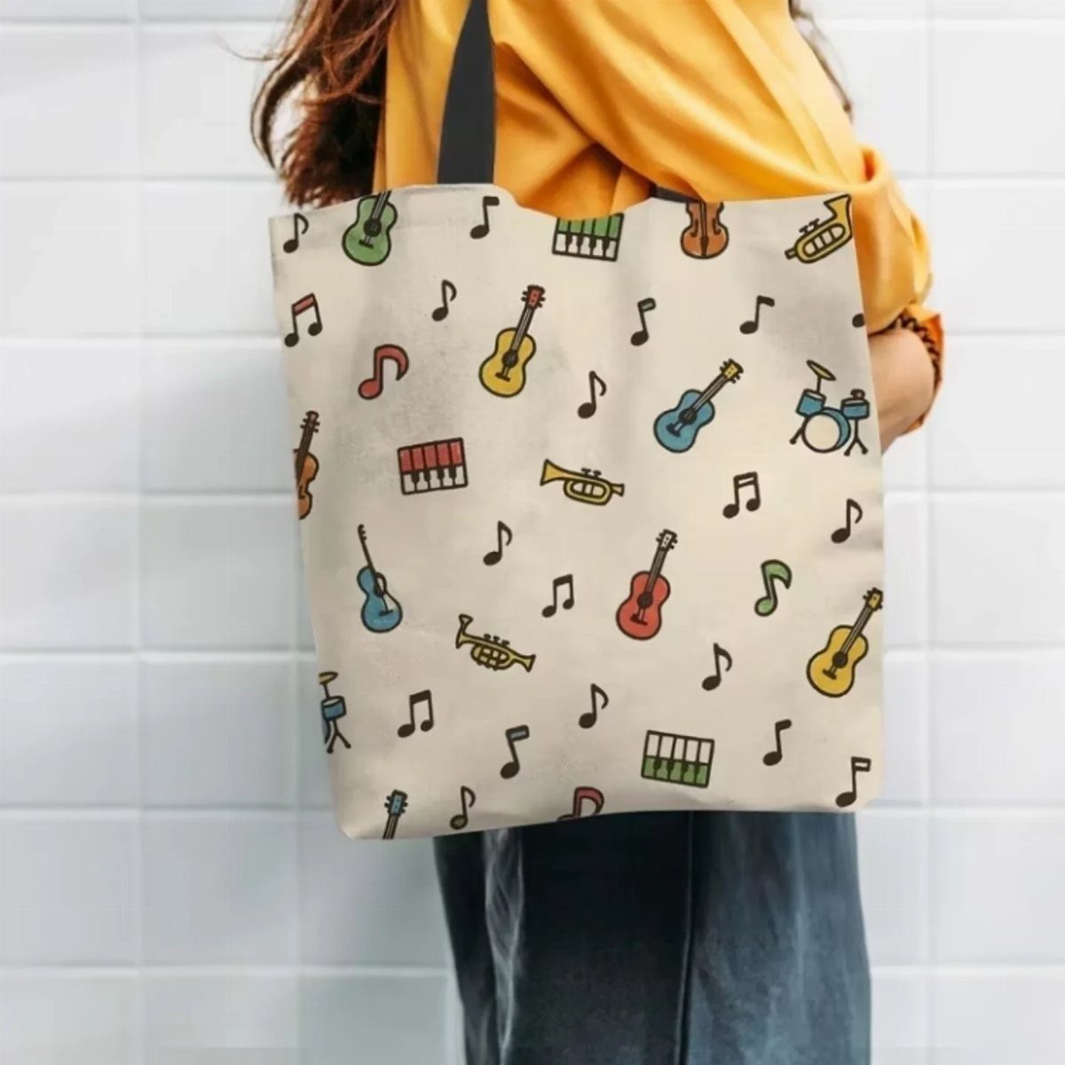 Cream tote bag with colorful musical instrument patterns carried by a person