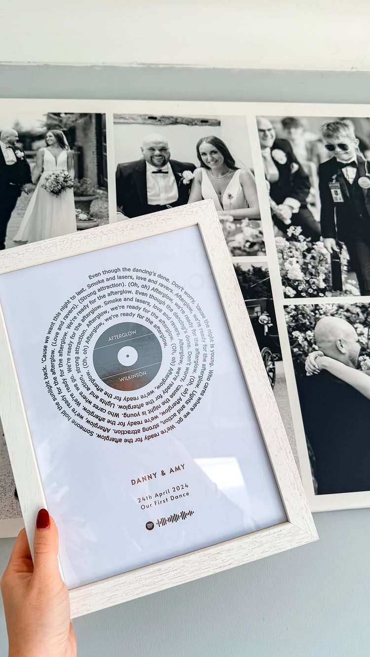 White framed print with song lyrics arranged in circles around a vinyl record.