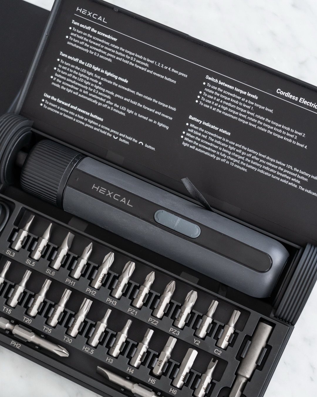 Cordless electric screwdriver and metal bits in a black organized tool kit case