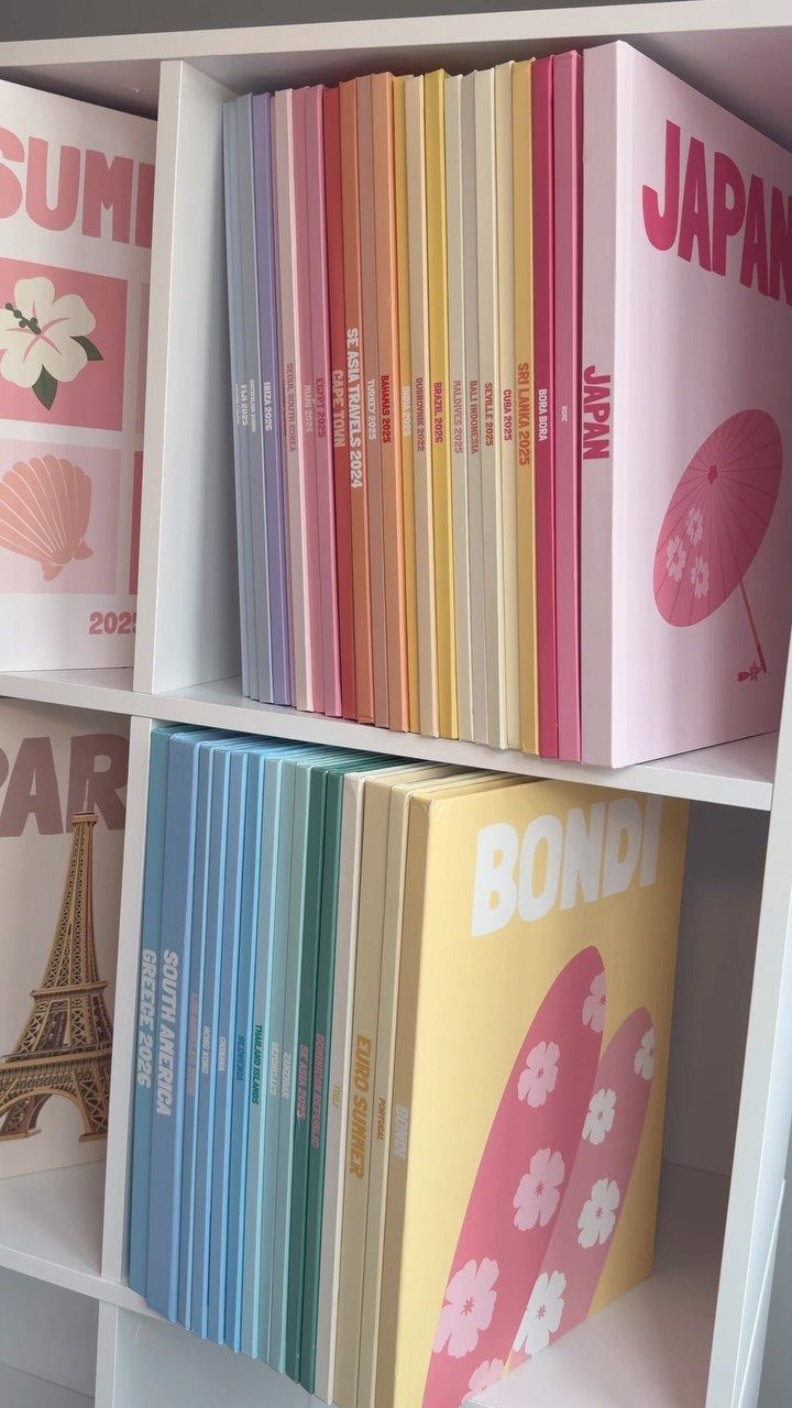Colorful travel albums on a white shelf featuring Japan and Bondi destinations.