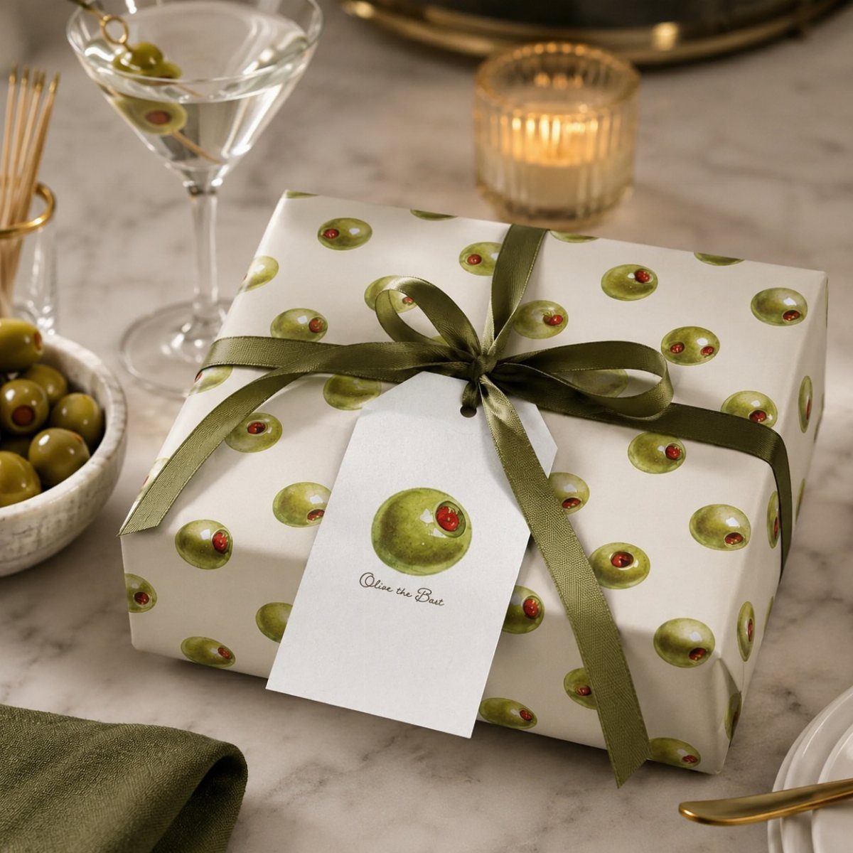 Wrapped gift box with olive pattern, green ribbon, and matching olive gift tag.