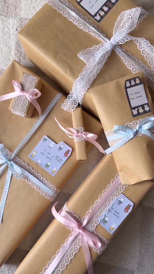 Brown craft paper wrapped gifts with lace ribbons, colorful bows, and bunny tags.