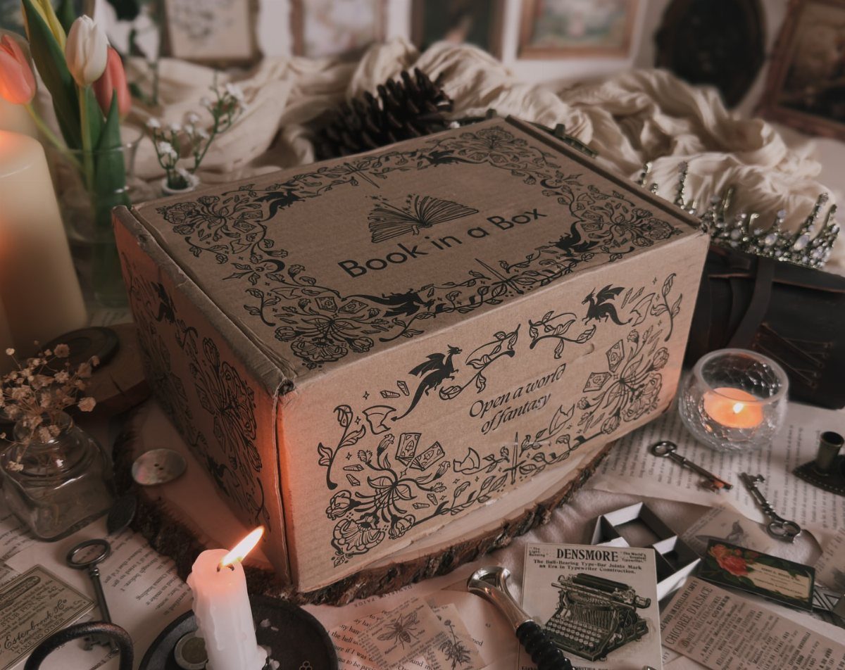 Cardboard Book in a Box subscription package surrounded by vintage keys and candles.