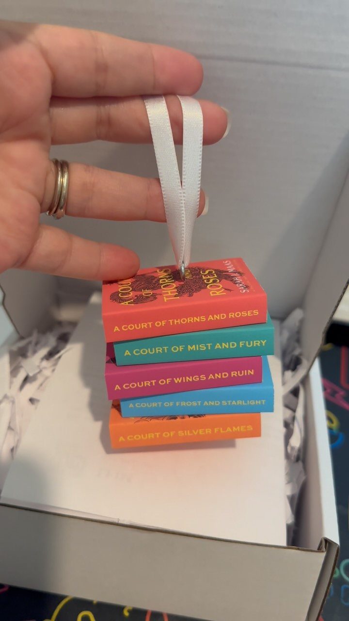 Miniature book stack ornament featuring ACOTAR series titles hanging from a white ribbon.